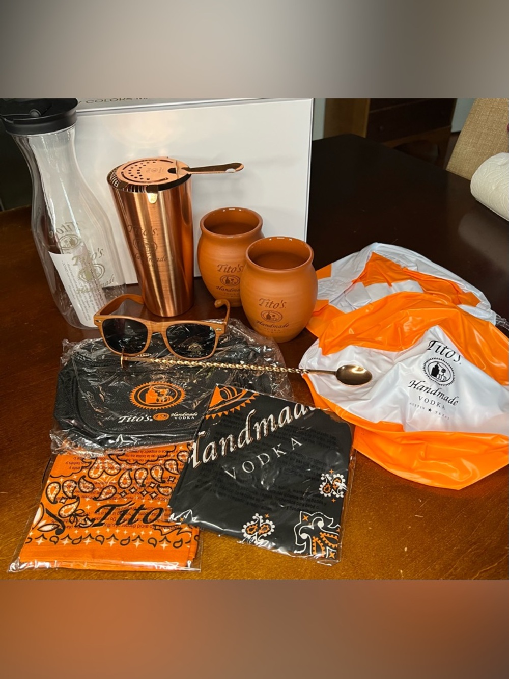 Lot of Tito’s items: cups, drink shaker, fanny pack, sunglasses, carafe
